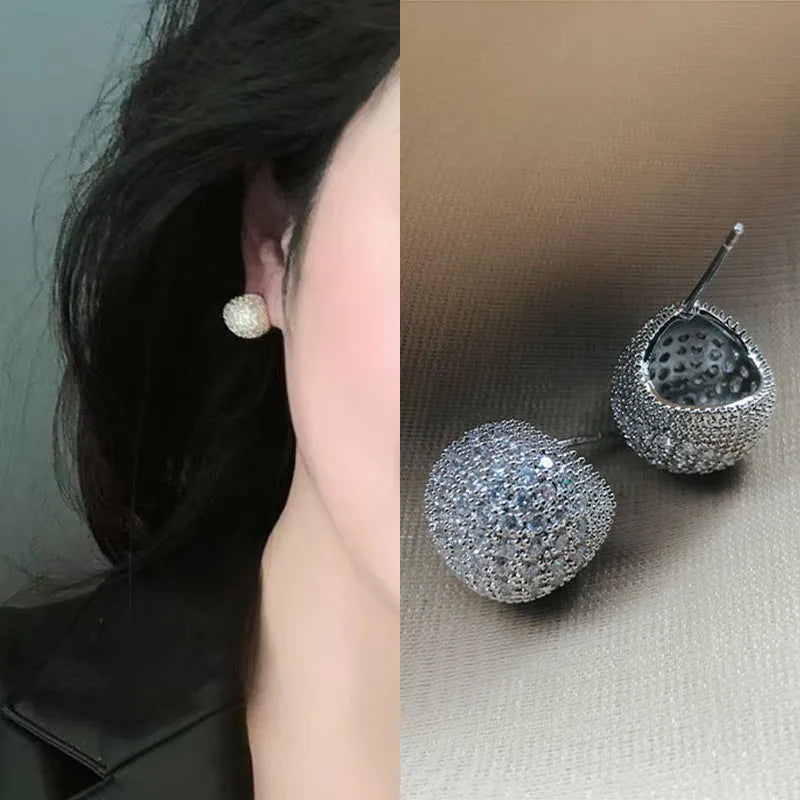 Gold and white drop-shaped geometric earrings with sphere elements and sparkling crystals