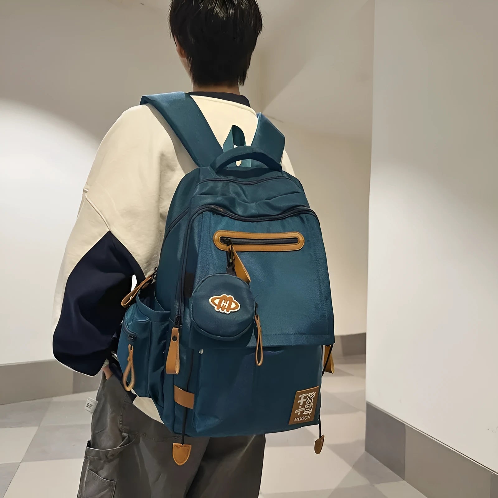 Large-capacity nylon backpack for middle school students in solid colour with curved shoulder strap and sewing line detail