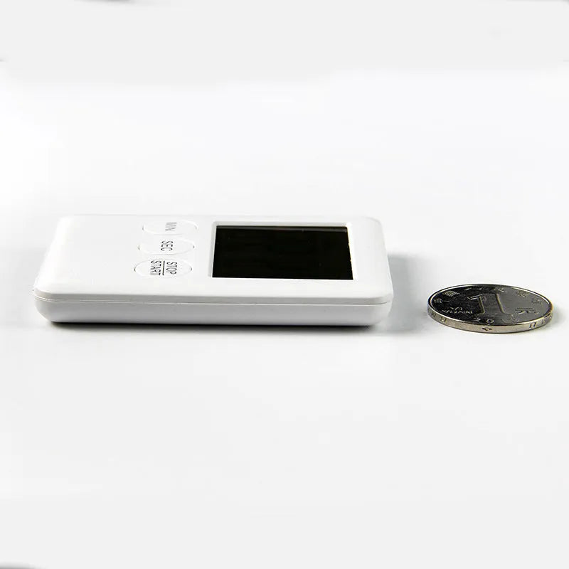 Square white digital kitchen timer with LCD display on magnetic refrigerator door