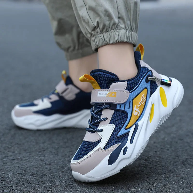 Boys' blue and black Velcro fastening sports running shoes on a white background.