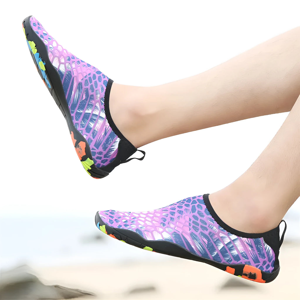 Blue and camouflage coloured beach wading shoes with Lycra uppers on a sandy background