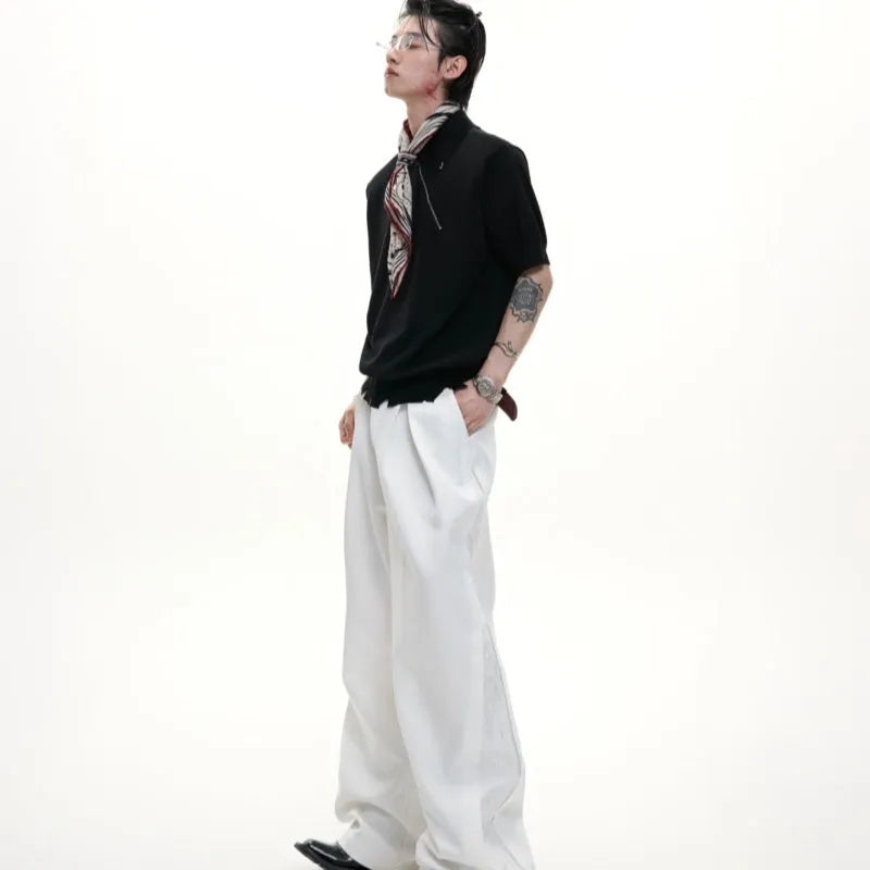 Man modelling a slim-fit black knitted polo shirt with an oblique diagonal zip closure and short sleeves.