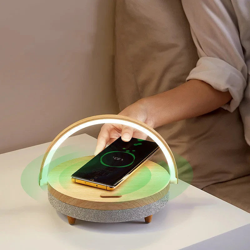 White multifunctional bedside lamp with wireless charging pad, Bluetooth speaker grille, and integrated phone holder in marble pattern finish.