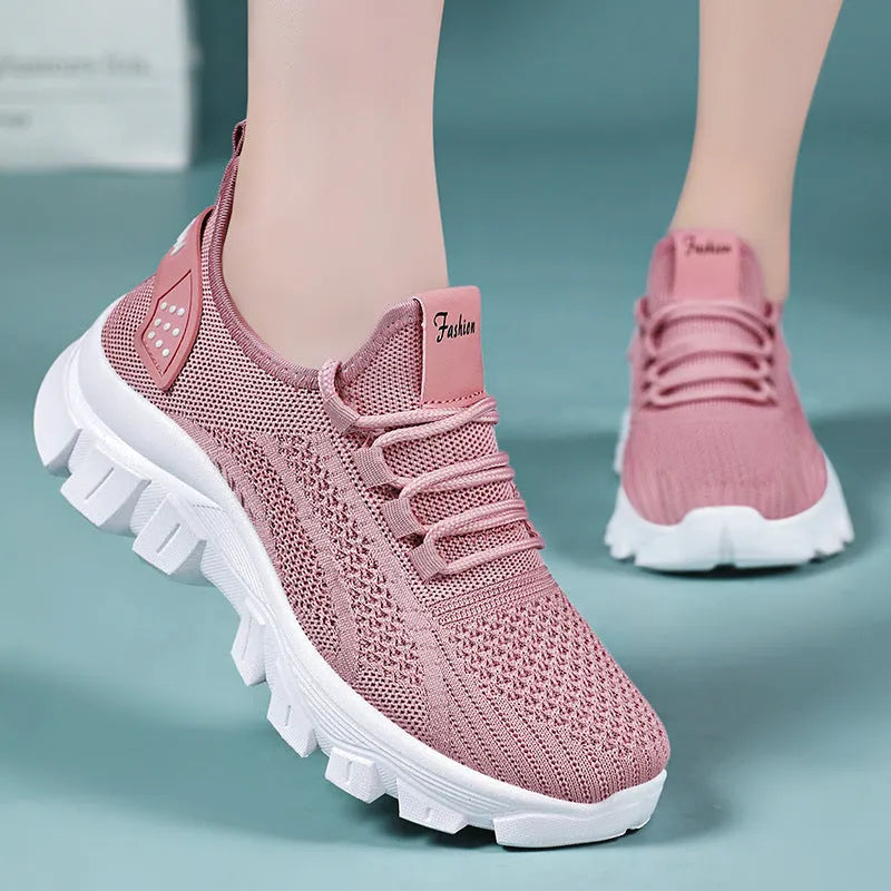 Women's white Flyknit sneakers with thick PVC sole and lace-up fastening on a neutral background.