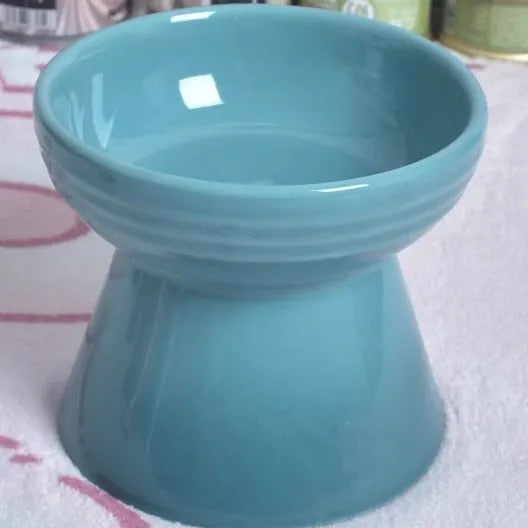 Ceramic anti-tumble pet bowl for dogs and cats with high foot and neck protector.