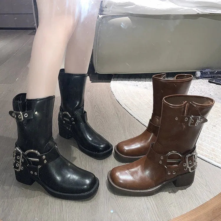 Women's black platform boots with belt buckle decoration showing mid-calf height