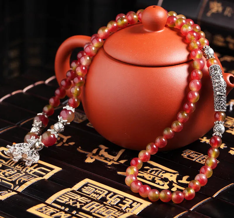 Natural watermelon crystal Chinese knot bracelet with elephant style beads.