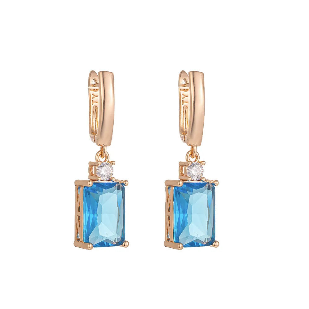 A pair of square gold and silver electroplated copper earrings showing geometric quadrilateral shape.