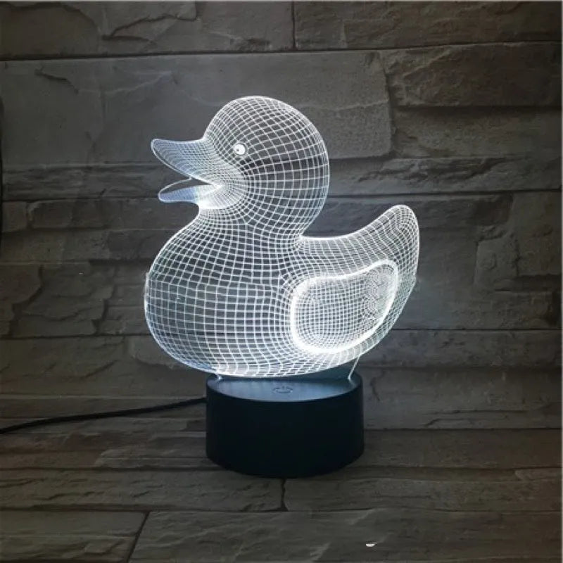 Little yellow duck 3D night light with remote control on a table, showing colourful LED illumination.