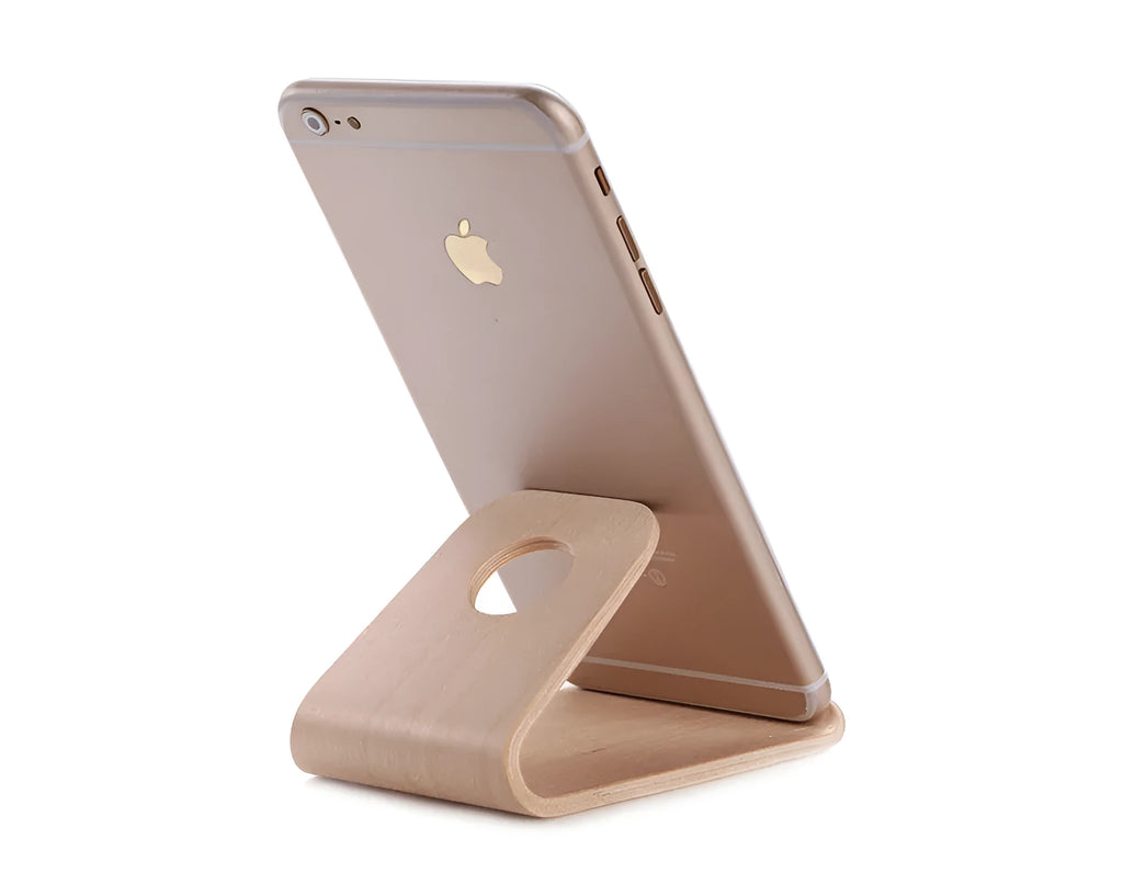 Wooden stand for iPhone in Walnut finish, placed on a desk, holding a phone for hands-free viewing