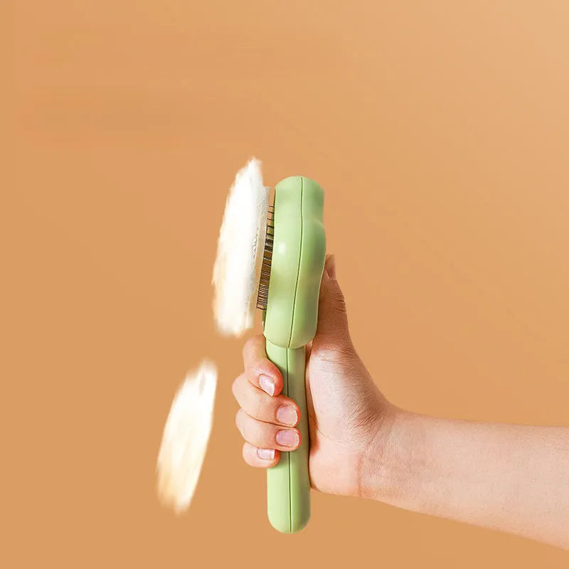 Green handled self-cleaning pet comb with stainless steel teeth on a white background.