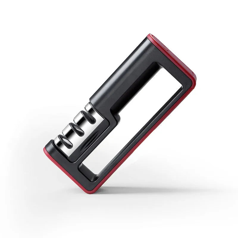 Black and red three-stage knife sharpener with non-skid rubber feet on a worktop