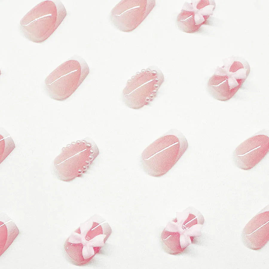 Short white French manicure press-on nails with decorative bow designs and European square shape