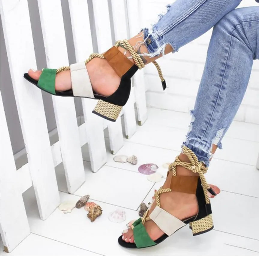 Women's beige suede sandals with thick middle heel, front strap, and ankle strap on a neutral background.
