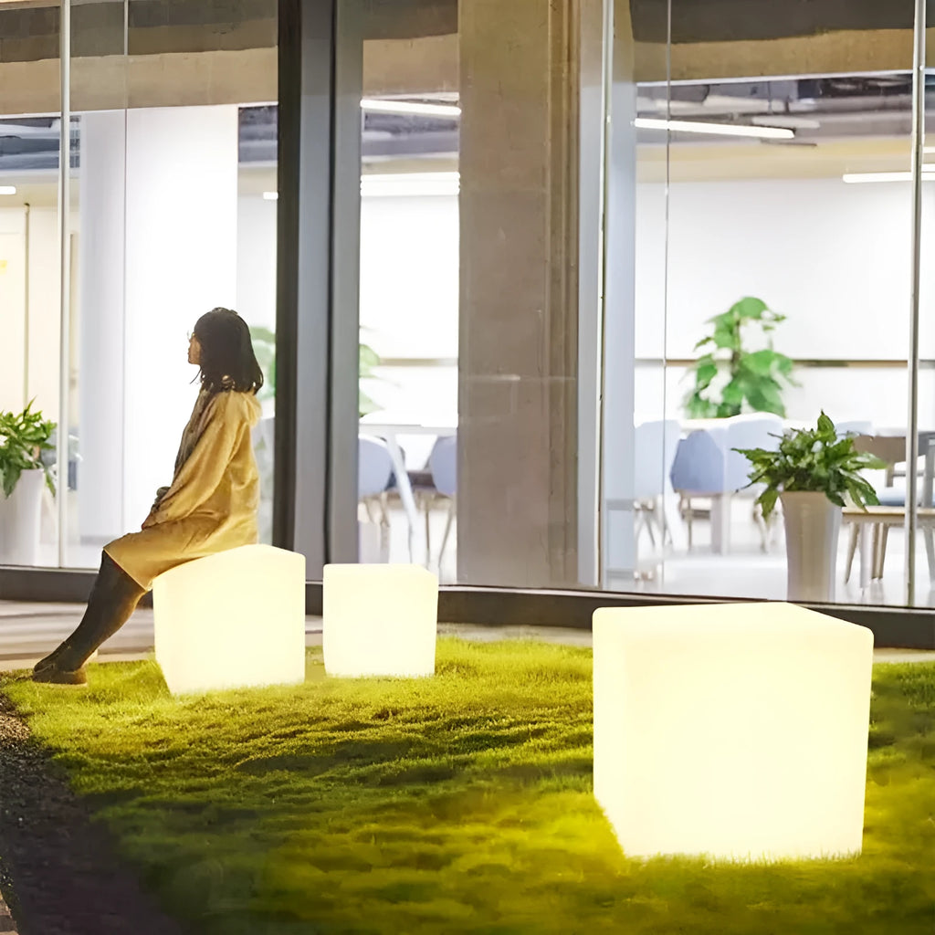 Modern LED illuminated cube stool in outdoor garden setting showing waterproof construction and integrated lighting
