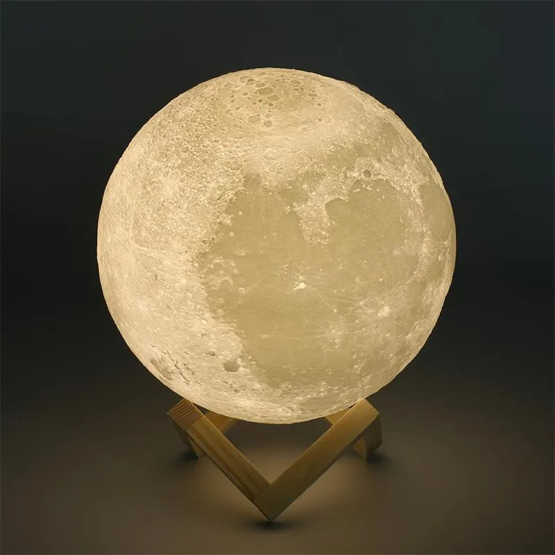 3D printed white moon lamp on a wooden stand with a glowing centre.