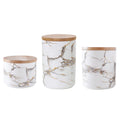 Three marbled ceramic jars with bamboo lids in large, medium and small sizes on a kitchen counter