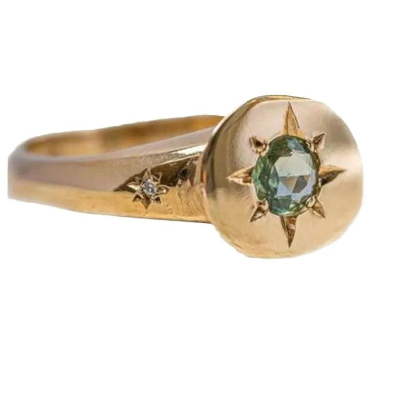Gold tone adjustable ring with oval band and star-shaped zircon stone.