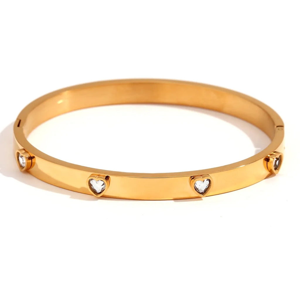 Golden electroplated stainless steel bracelet with a micro-inlaid peach heart charm for women.