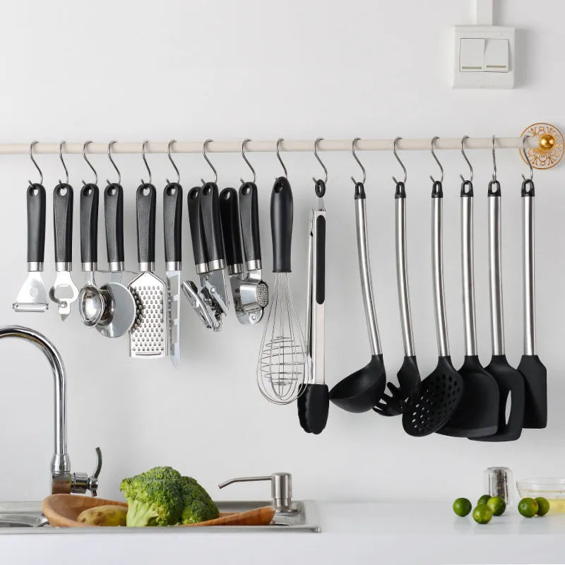 Black silicone kitchen utensil set of 16 pieces including spatulas and spoons on a countertop