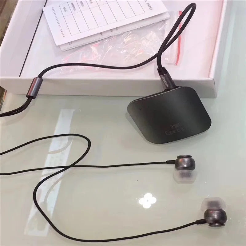 Black lavalier-style Bluetooth audio receiver for wireless headphones with a 10m range.