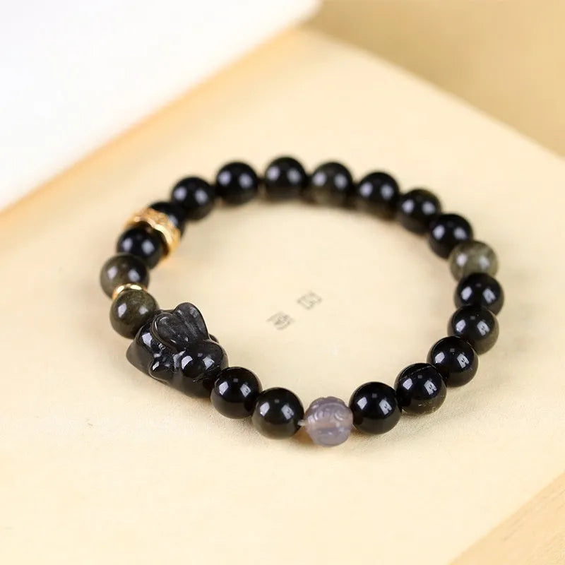 Handmade national style bracelet with lying rabbit Jin Yaoshi charm on neutral background, 8mm beads