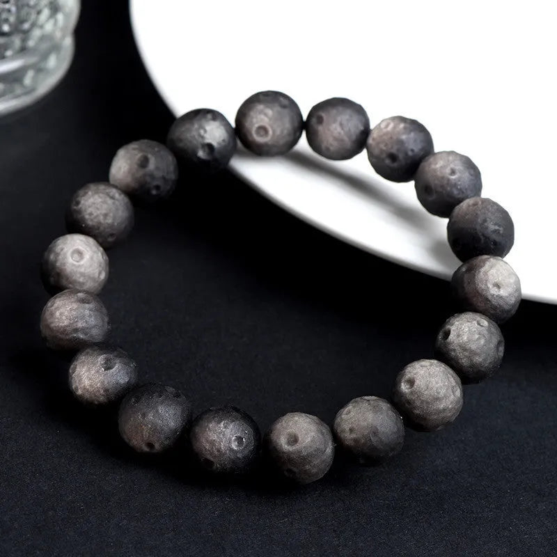 Obsidian crater ball bracelet in silver stone meteorite colour with textured round beads.