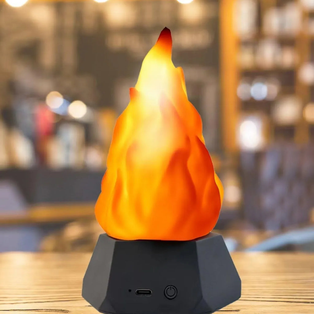 Flame-shaped outdoor decorative light with vinyl shell and gold charging base on a garden table