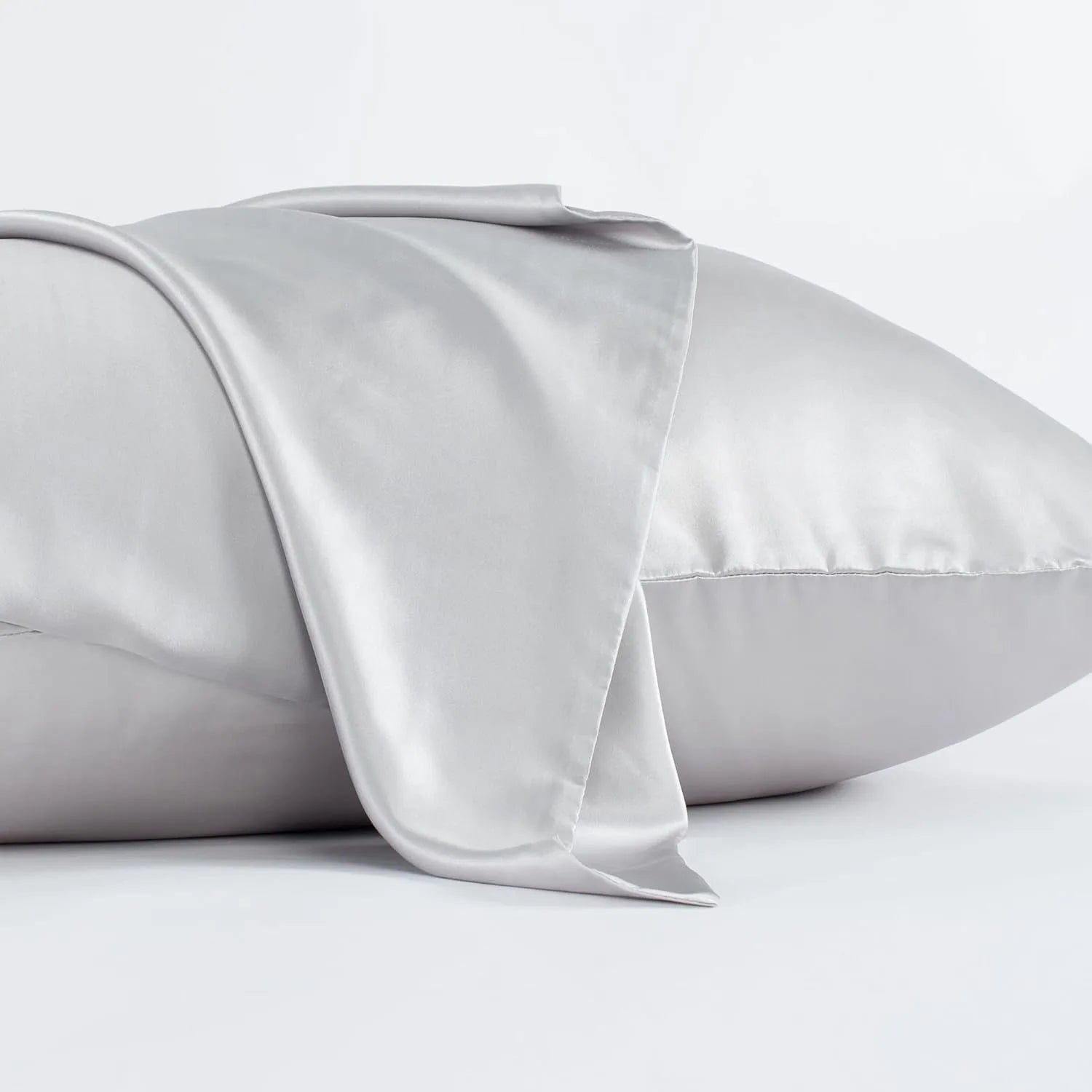 Dark gray 19 M silk envelope pillowcase with envelope closure on a bed.