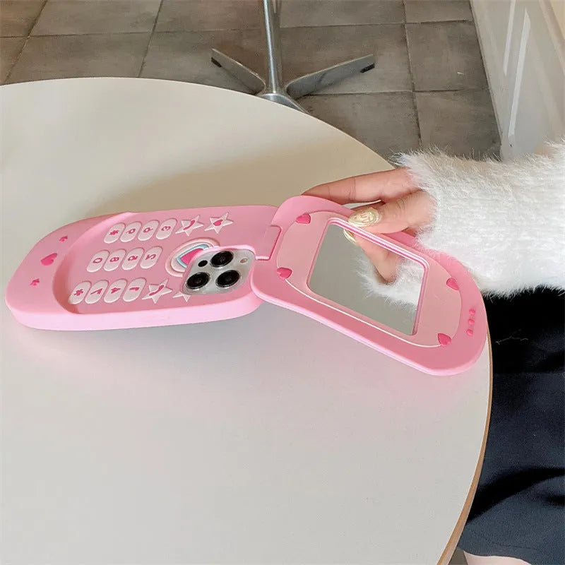 Light pink silicone flip phone shaped mirror case for iPhone on a white background.