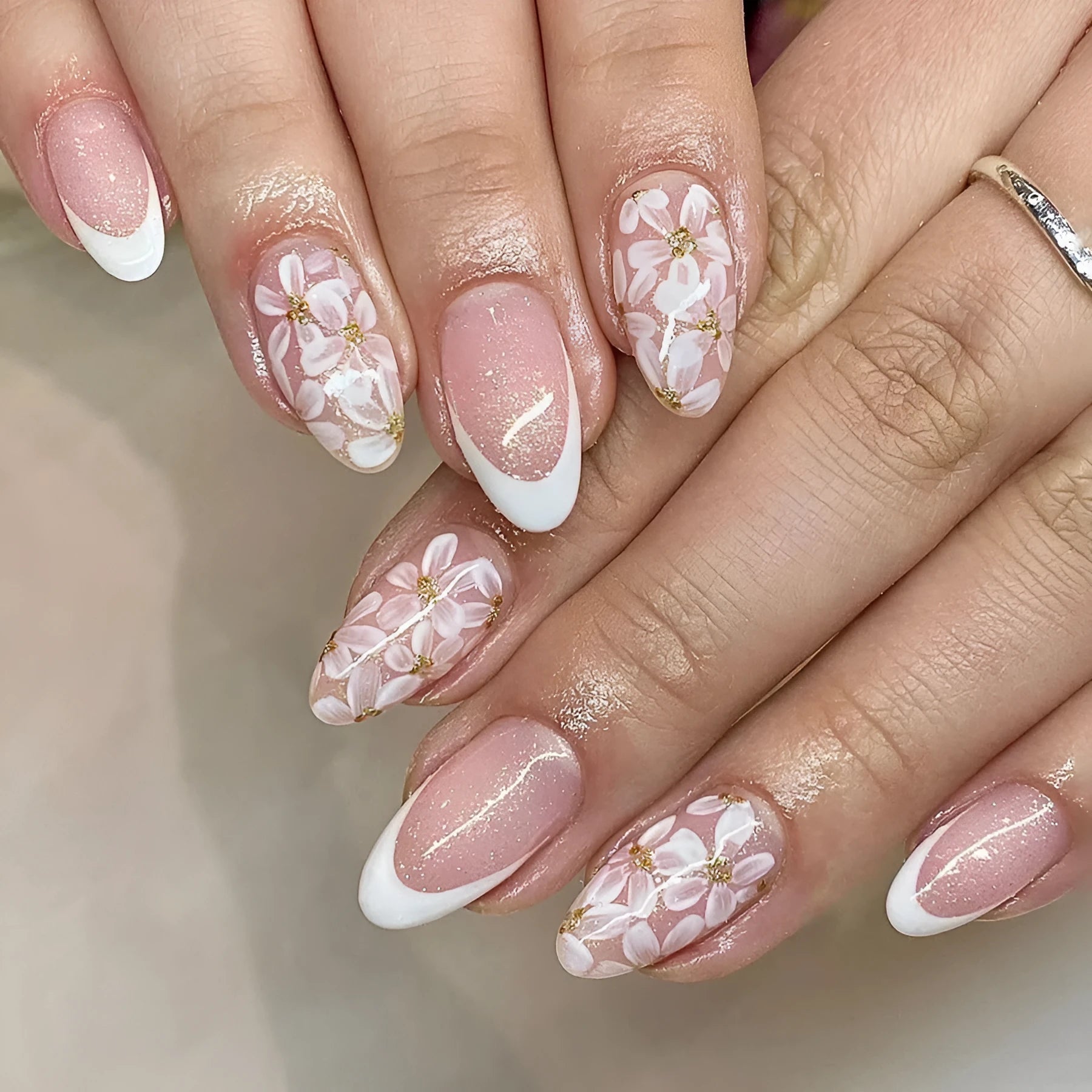 Short almond shaped French style artificial nails with glitter and flower pattern in colour C625