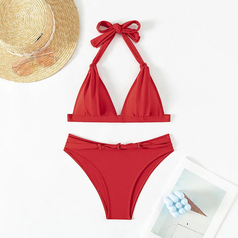 Red women's lace-up halterneck bikini set with matching shorts on mannequin