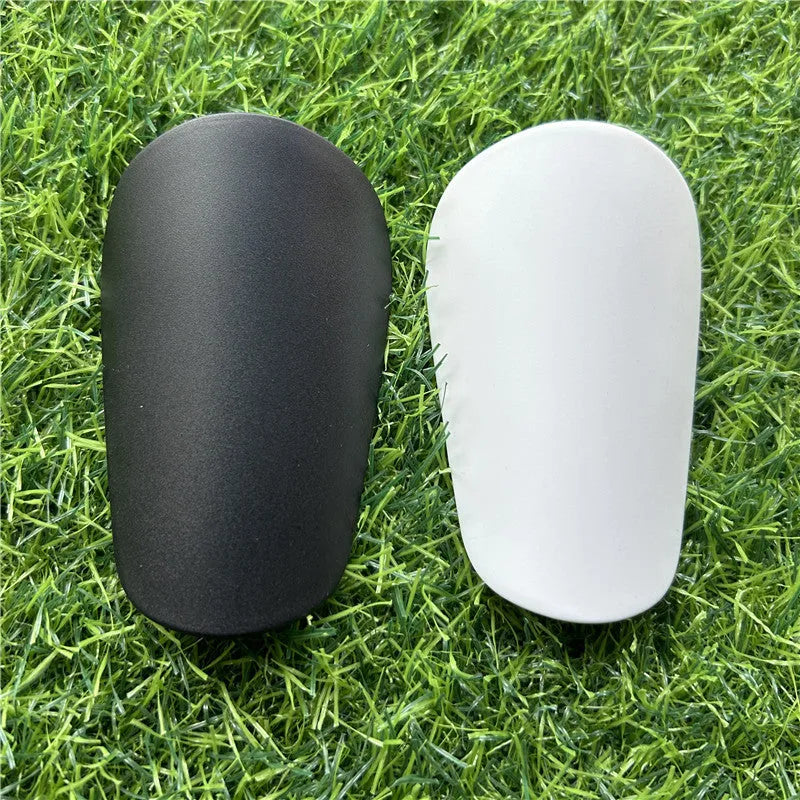Extra small mini football shin guards measuring 8x5cm in black and white plastic