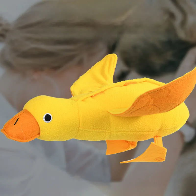 Yellow plush duck dog toy with squeaker and treat dispensing holes for training and chewing.