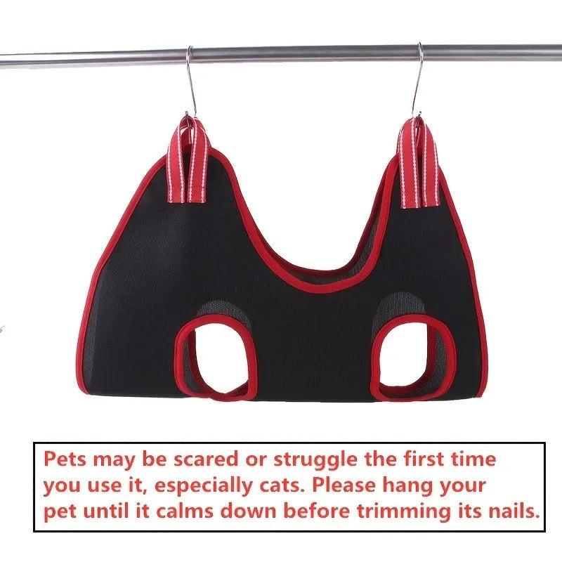 A grey pet grooming hammock restraint bag hanging from straps, with a cat inside for nail trimming, alongside grooming tools.