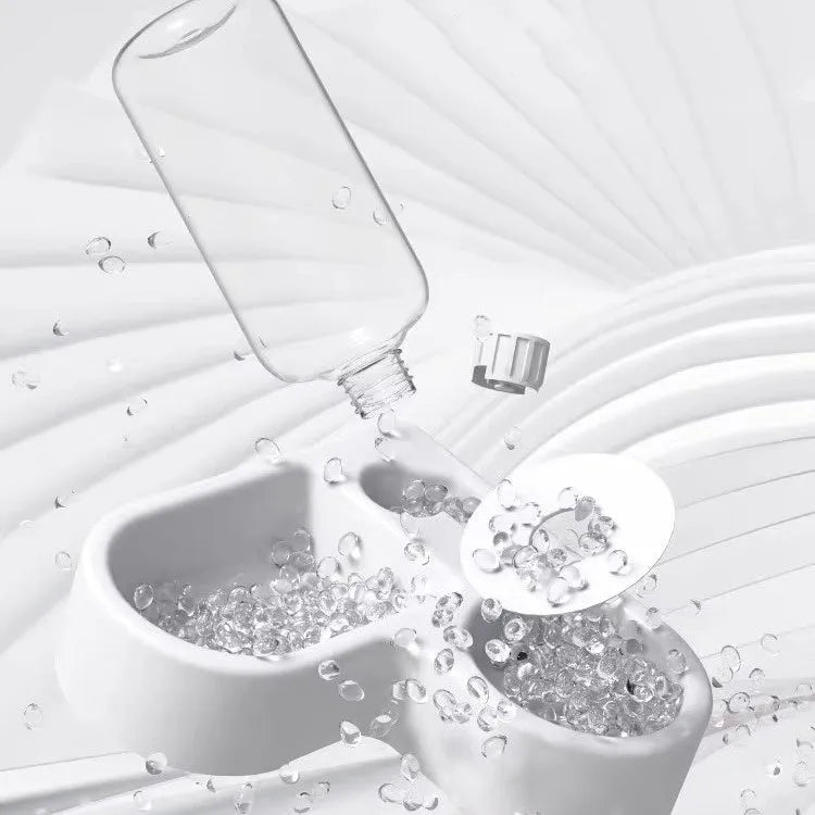 White pet water fountain for cats and dogs indoors on a kitchen floor.