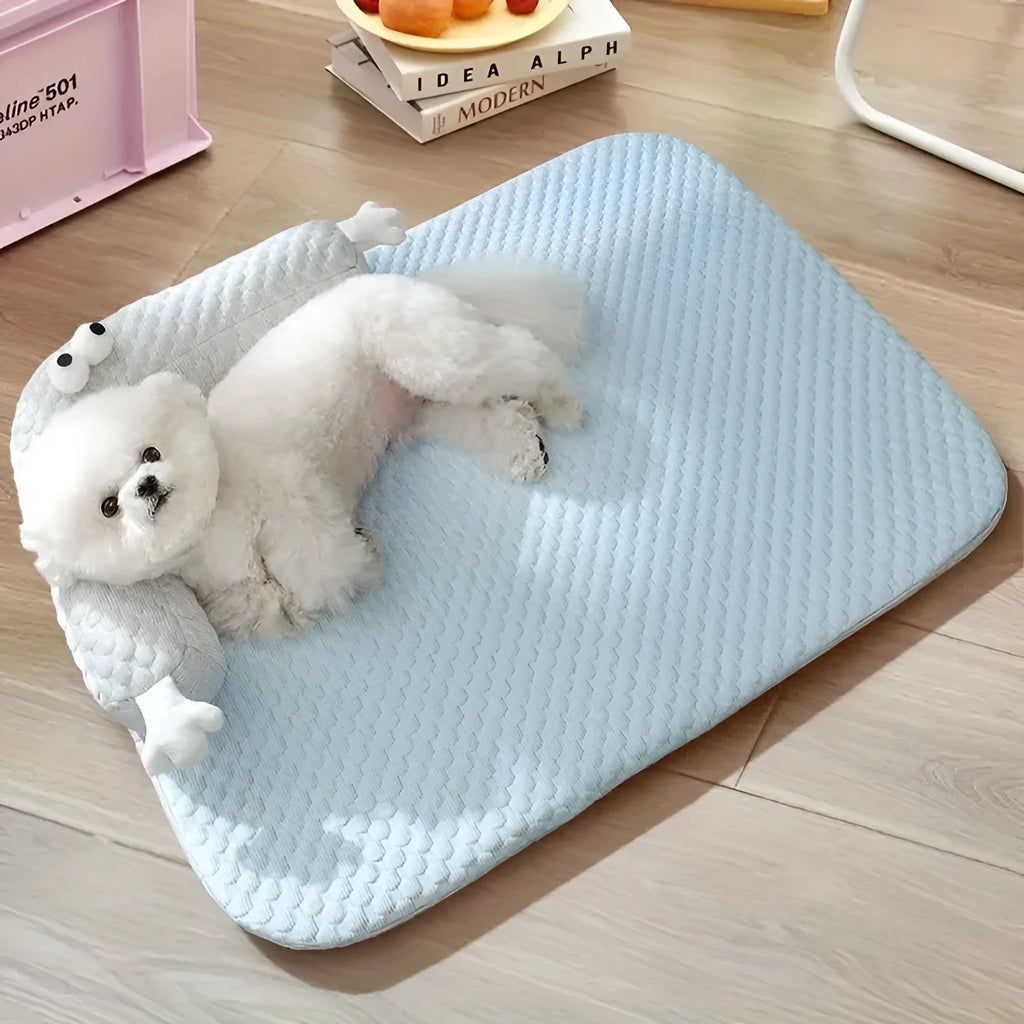 Blue big-eyed monster design breathable pet cooling bed for dogs and cats on a wooden floor.