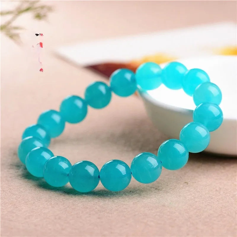 Polished Amazonite scattered beads in ice colour with size options for jewellery making next to crystal bracelet