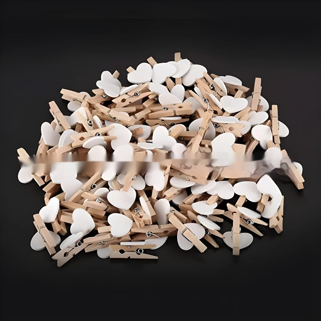 Five handmade solid wood heart-shaped clips in red, pink, white, yellow colours on a wood surface.