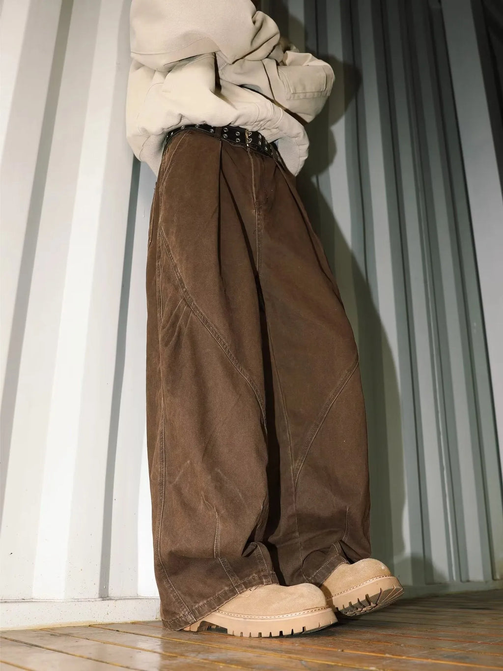 Men's pleated straight leg loose fit trousers in a black stripe pattern, showing front and side details.