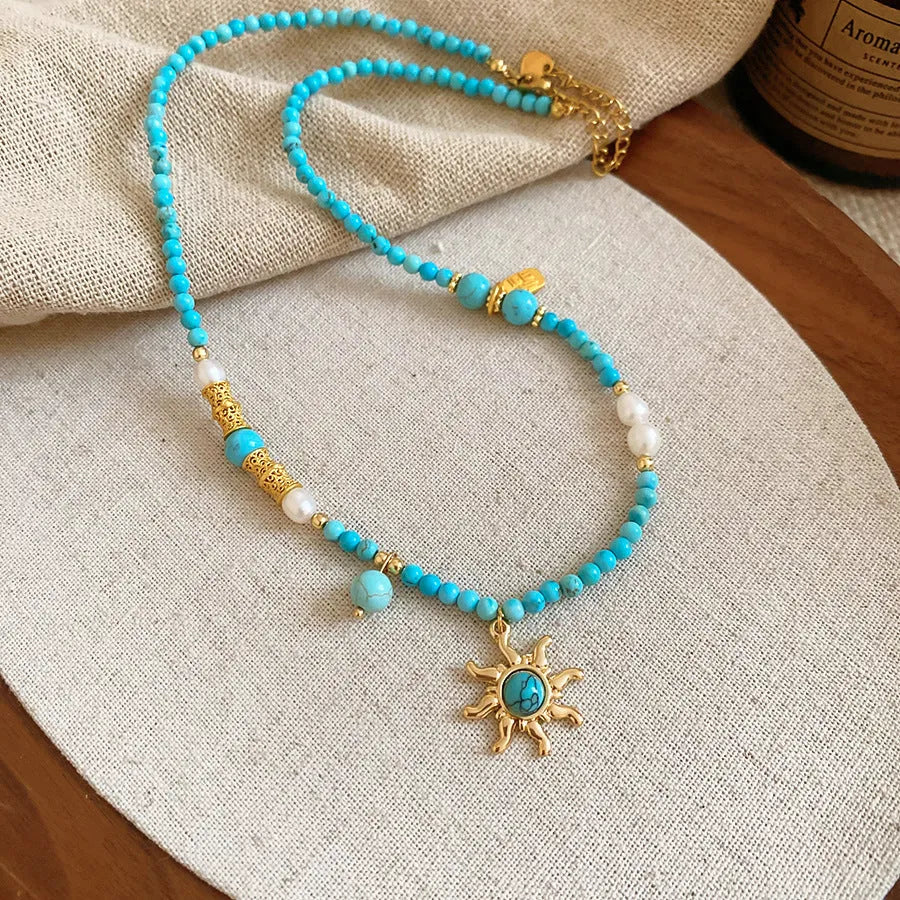 Freshwater pearl necklace with sun motif stone pendant on an adjustable clavicle chain.