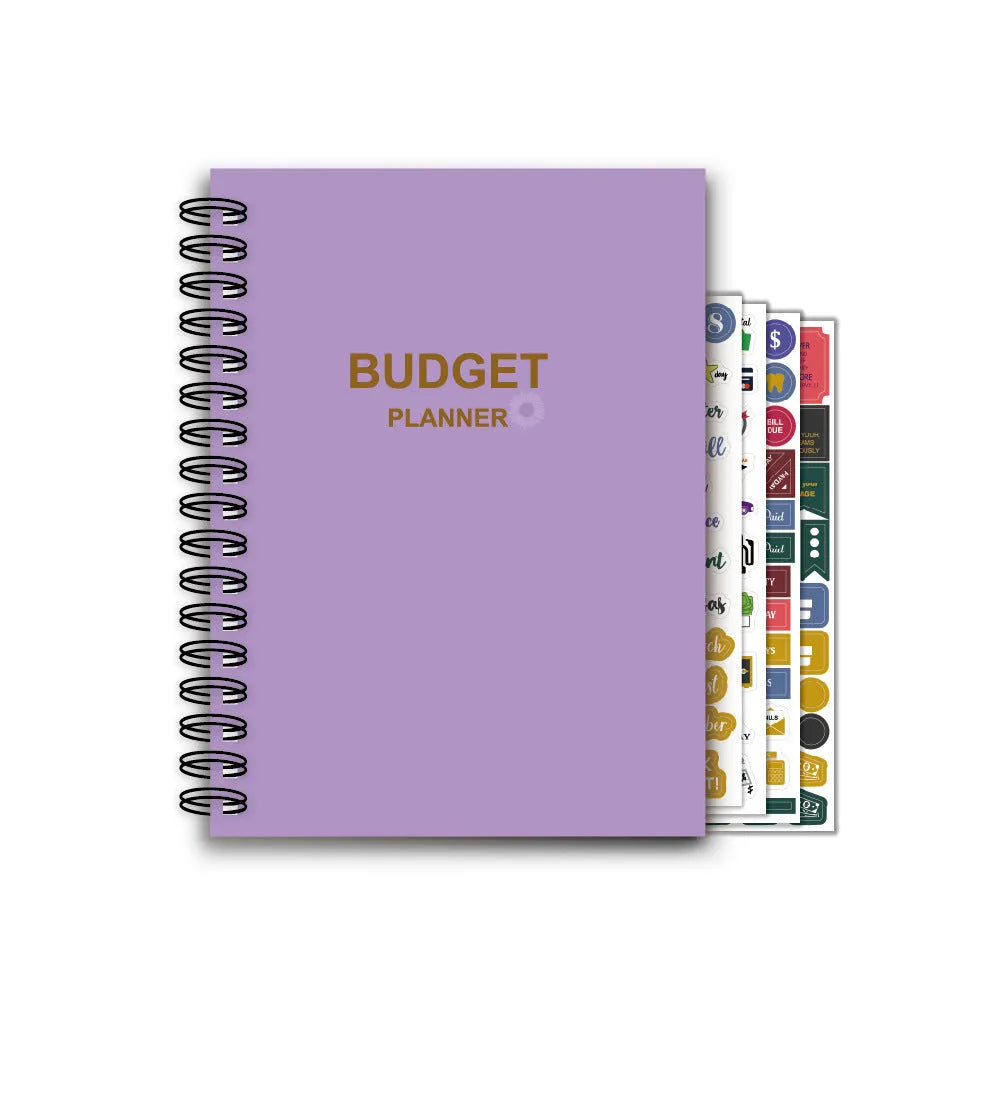 Purple coil-bound financial planning notebook open on a desk with pen, stickers, and paper clips.