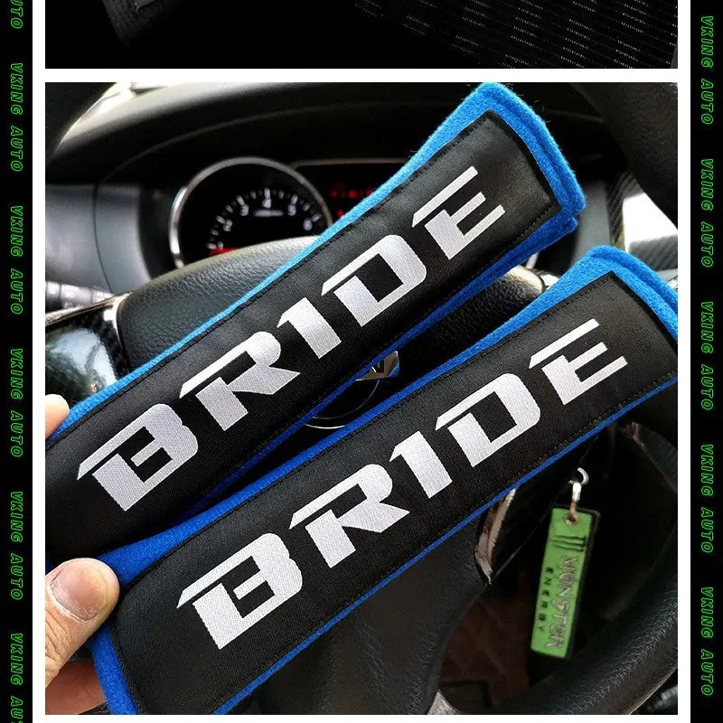 Pair of black car seatbelt shoulder pads made from cotton sponge cloth, showing embroidery detail.