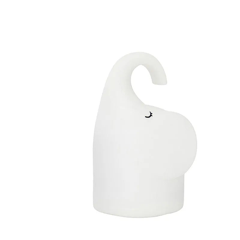 Soft silicone elephant night light with warm white LED glow on bedside table