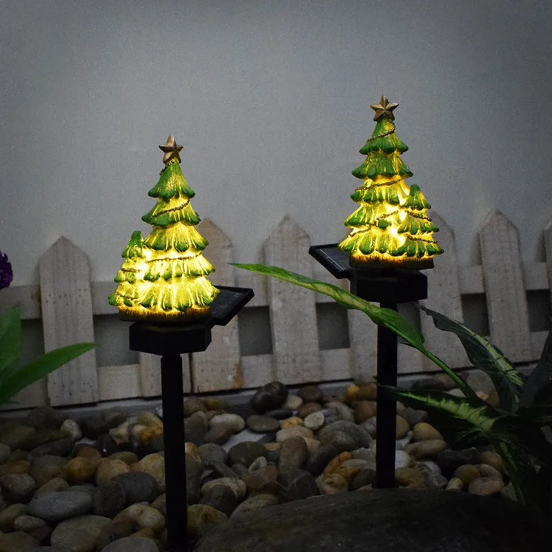 Solar Christmas tree ground plug light with resin body, warm white LED, and 40x40mm solar panel on a lawn