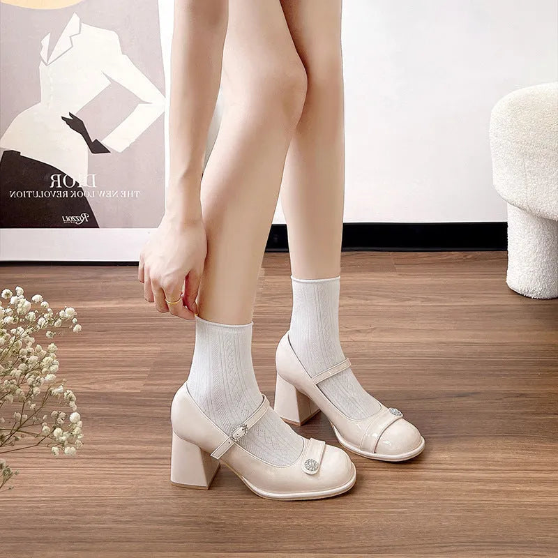 Women's black patent leather chunky heel shoes with round toe and buckle.