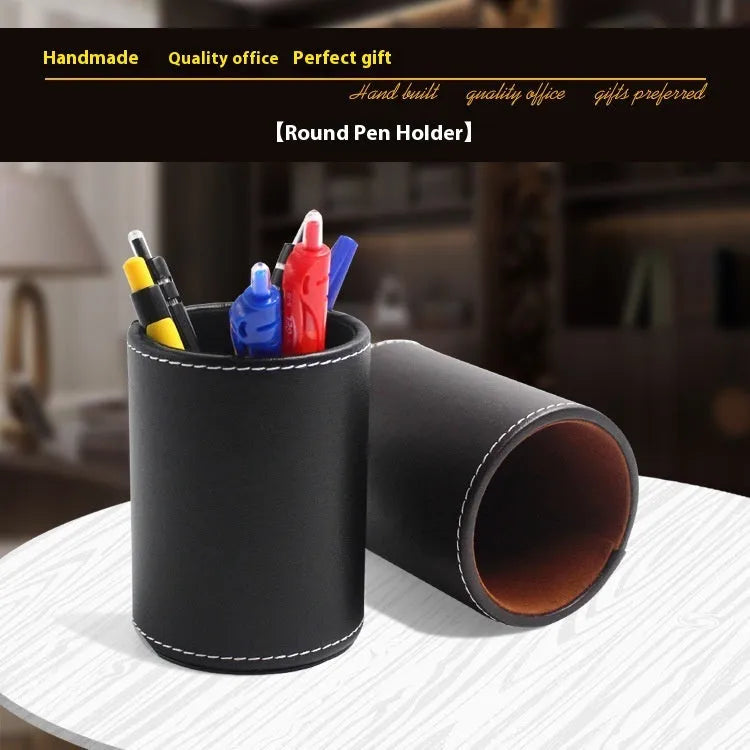 Round black leather pen holder on desk with pens