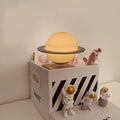Maglev floating moon planet night light with LED illumination and astronaut figures on a dark surface.