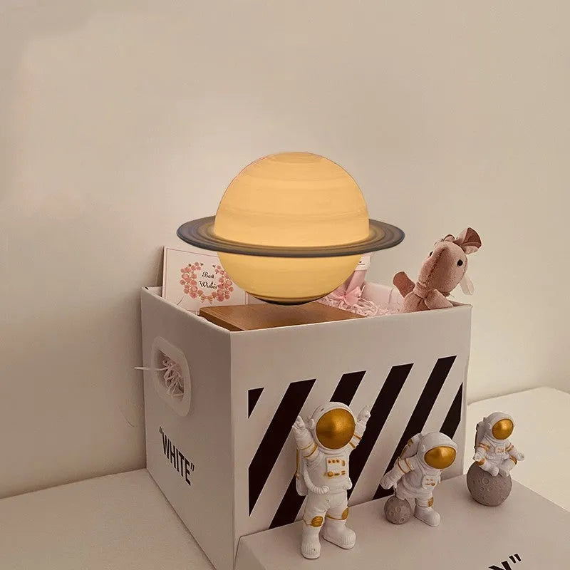 Maglev floating moon planet night light with LED illumination and astronaut figures on a dark surface.