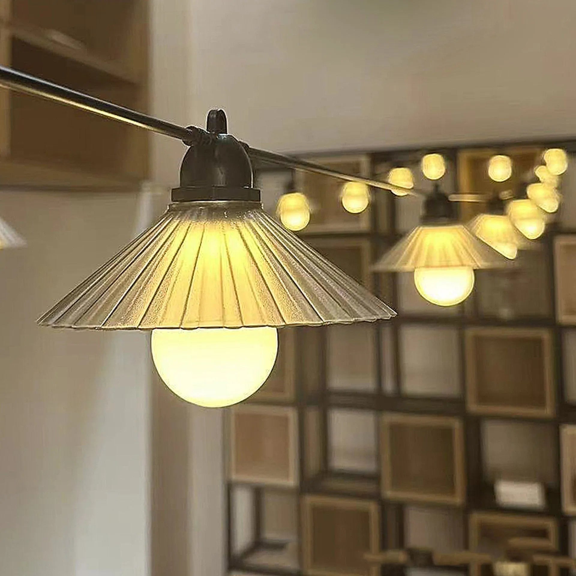 Outdoor LED string lights with flower-shaped globes in four colours, hanging in a garden.